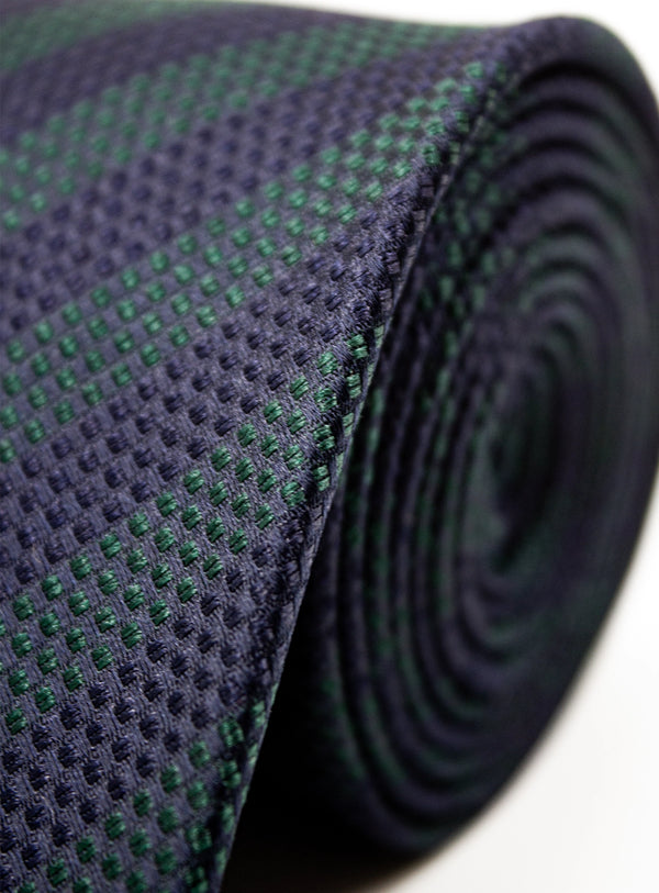 Roll of textured black and green fabric on a white background