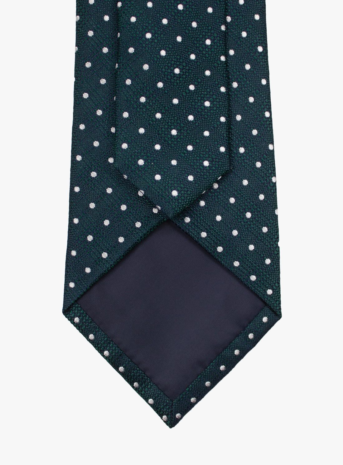 Green tie with white polka dots and a matching pocket square on a white background