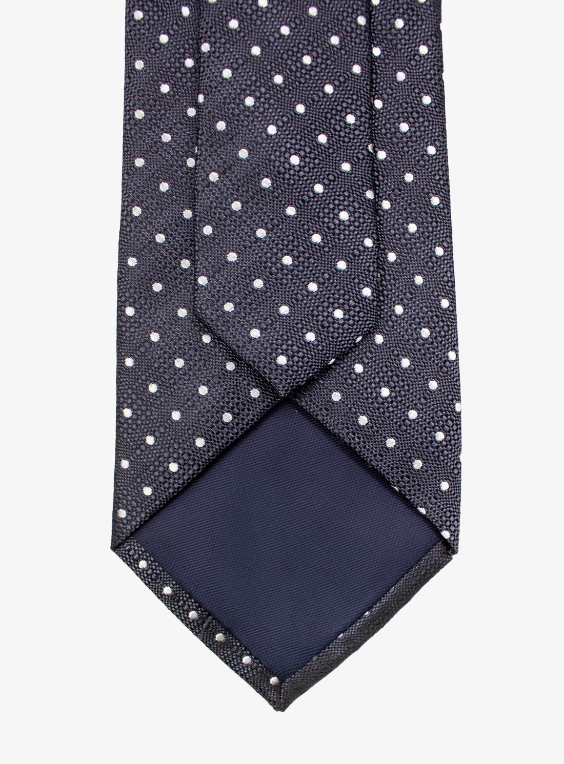 Navy tie with white polka dots and matching pocket square on a white background