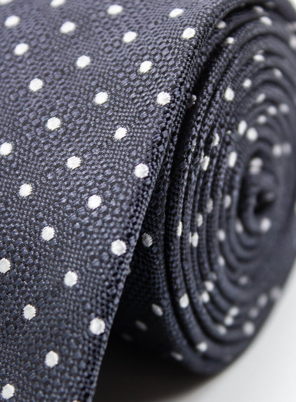 Roll of black fabric with white polka dots on a light gray background