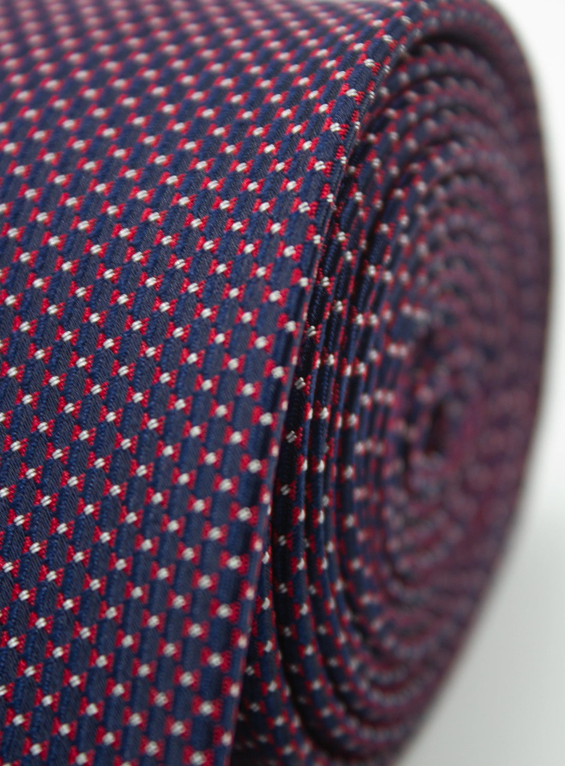 Close-up of a patterned tie with red and white details on a blue background