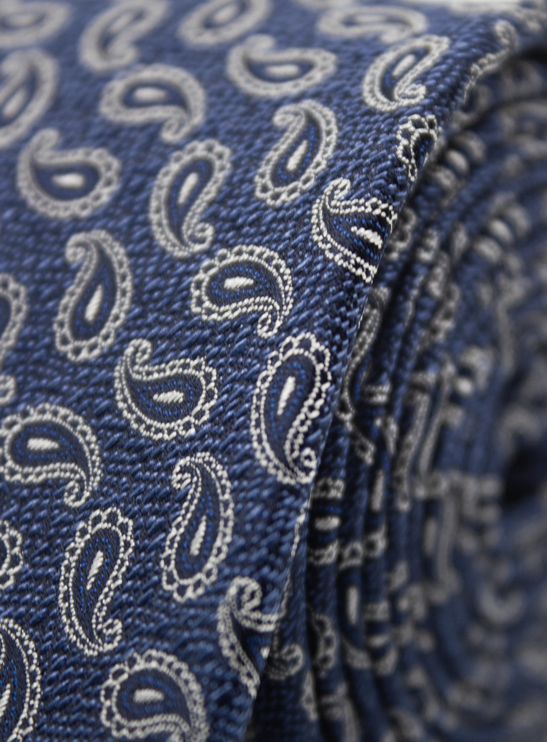 Close-up of a blue tie with white paisley pattern