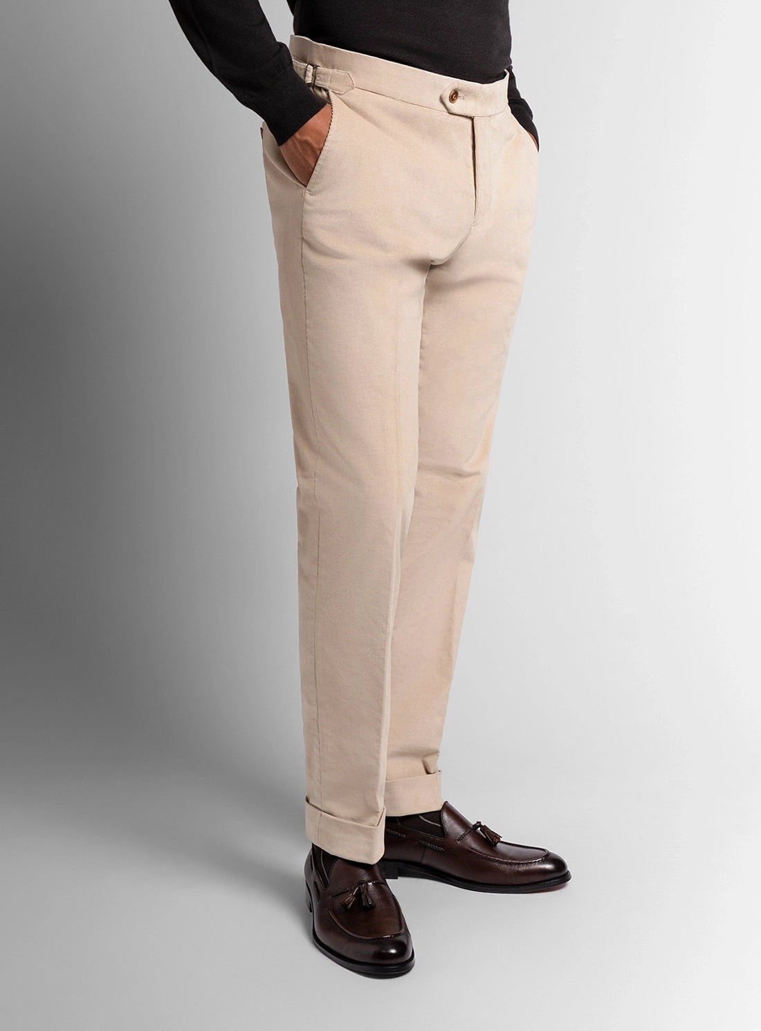 Beige pants worn by a person on a gray background