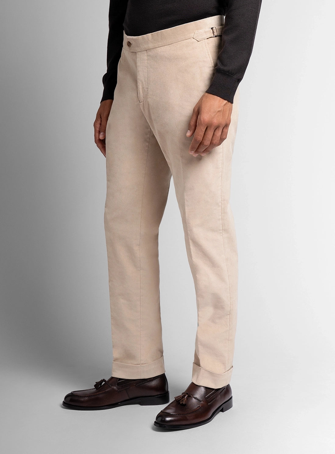 Beige pants worn by a person on a gray background