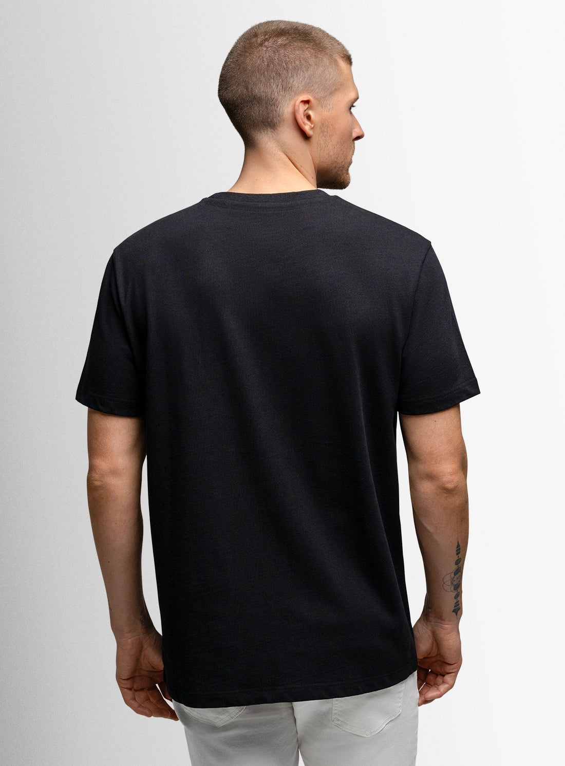Man wearing a black t-shirt on a plain background