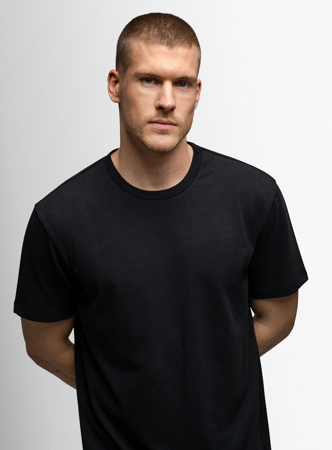 Man wearing a black t-shirt against a plain background