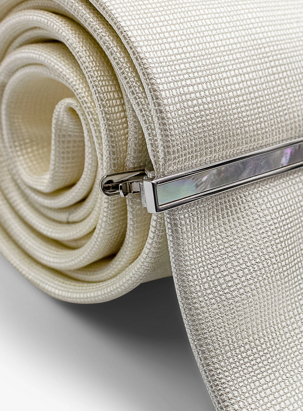 silver with mother of pearl tie bar on tie