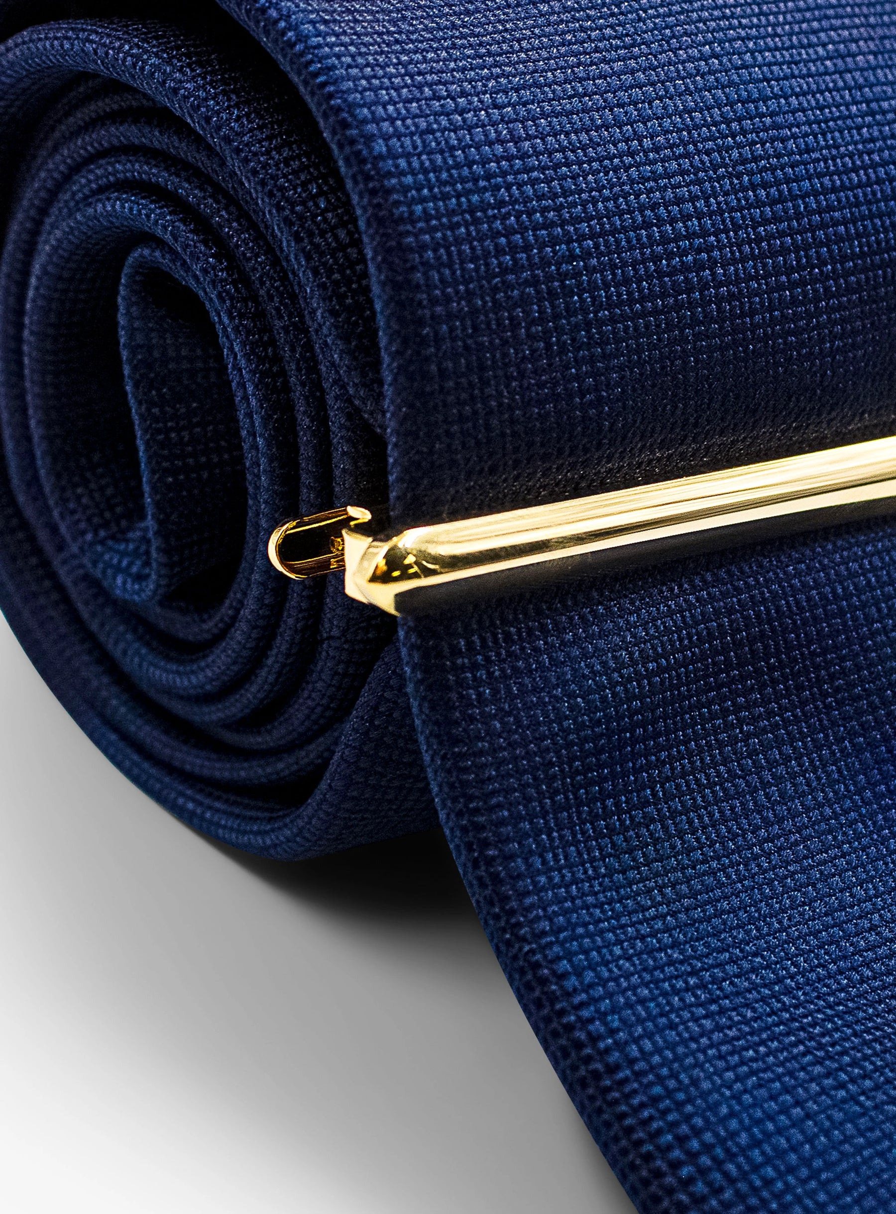 smooth gold tie bar on tie