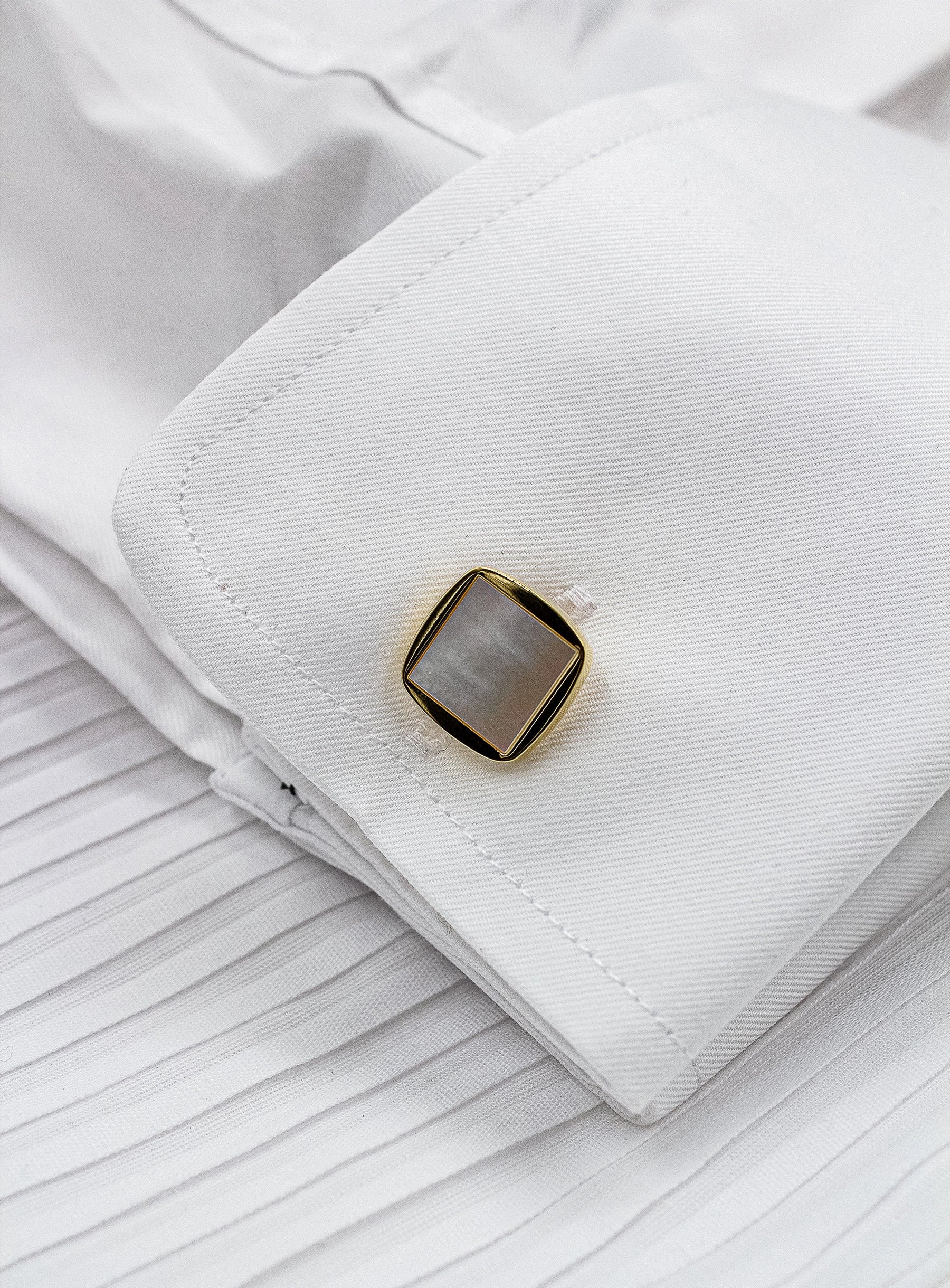 square gold with mother of pearl cufflinks in shirt